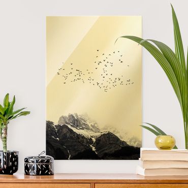 Glasbild - Vogelschwarm vor Bergen Schwarz Weiß - Hochformat 3:2