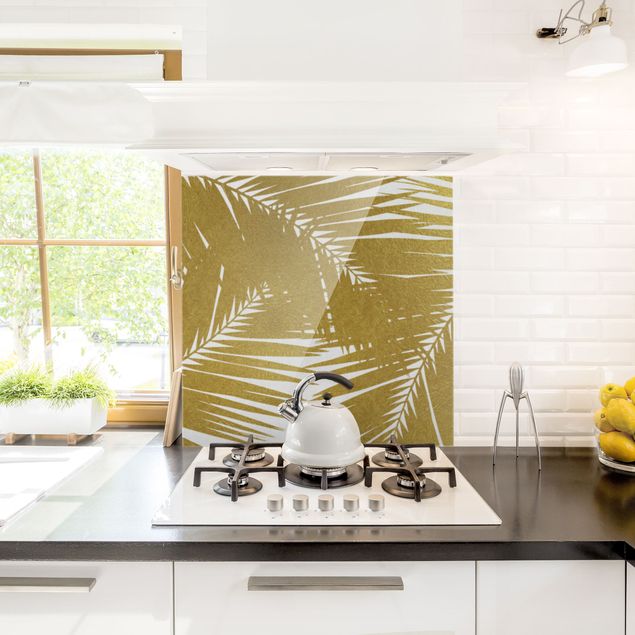 Glasrückwand Küche Blumen Blick durch goldene Palmenblätter