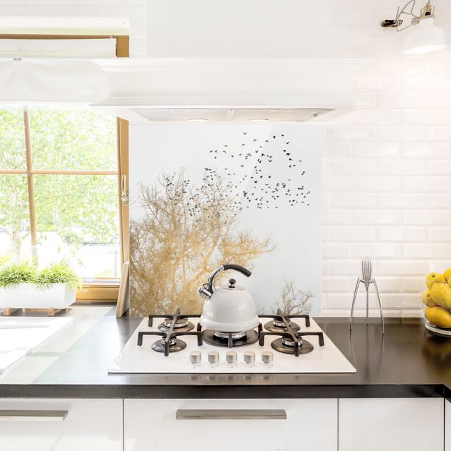 Glasrückwand Küche Vogelschwarm vor goldenem Baum