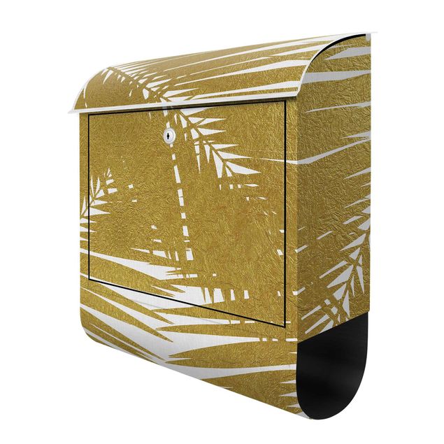 Briefkasten modern Blick durch goldene Palmenblätter